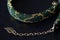 Dark green beaded necklace with golden print on a dark background