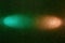 On a dark green grainy background, a gradient turquoise and pink beam of light