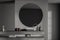 Dark grey bathroom vanity area with round mirror