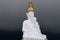 Dark grey clouds as backdrop for the five white sitting Buddhas at Wat Pra That, Pha Sorn Kaew, in Khao Kor, Phetchabun, Thailand.