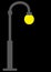 A dark grey gray street light lamp with yellow incandescent bulb black backdrop