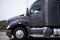 Dark grey powerful modern big rig semi truck tractor profile run