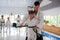 Dark-haired aikido trainer putting belt on waist of girl