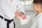 Dark-haired boy shaking hands with his aikido trainer