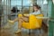 Dark-haired businesswoman sitting in nice comfy yellow armchair