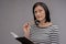 Dark-haired chemistry teacher feeling busy while composing final test