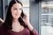Dark-haired cute woman feeling fascinated while talking by phone