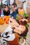 Dark-haired funny boy wearing skeleton Halloween costume eating hand cookie