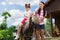 Dark-haired girl enjoying horse riding with her caring mother