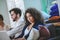 Dark-haired girl with laptop on couch, friends at distance