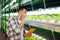 Dark-haired male agriculturist planting lettuce in greenhouse