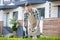 Dark-haired male in protective glasses pruning bushes outside