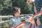 Dark-haired man holding a kite and showing it to his son