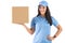 Dark-haired smiling courier in blue cap and t-shirt uniform happily holding a cardboard parcel ready to deliver. Isolated