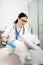 Dark-haired vet wearing glasses taking care of white dog