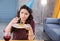 Dark-haired woman burning candle on little birthday muffin