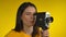 Dark-haired woman cinematographer is using a retro camcorder for shooting video