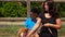 A dark-haired woman is leading a pony by the horse leash