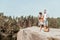 Dark-haired woman looking at her man while having rest in forest near big lake