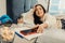 Dark-haired woman taking her red phone from the bedside cabinet