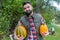 A dark-haired young farmer with pumpkins looking contented