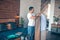 Dark-haired young man in white tshirt getting clothes ready