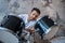 Dark-haired young man in a white tshirt sitting at the drums