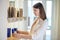 Dark-haired young shop assistant scrutinizing the new cosmetics in a shop