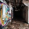 Dark Hallway and Colorful Graffiti Covered Wall in an Abandoned Building.