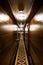 Dark hotel corridor. A long carpet with a pattern, wooden wall cladding. Deserted hotel corridor