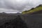 Dark Iceland landscape with green moss and black road, Iceland