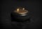 A dark illustration of an elegant black granite curling stone with a shining golden handle. The concept of an Olympic sport. 3D