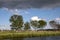 Dark looming thunder clouds above a river and a row of birches on the bank in the Nieuwkoop lakes in the Netherlands