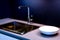 Dark marble wash basin with glossy metal mixer. Colored backlight. White plates.