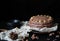 Dark moody photography of a fancy chocolate cake with walnuts on