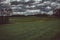 Dark moody sky over meadow and forest