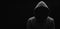 Dark mysterious man in a hoodie is hiding his face, hacker, anonymous