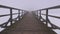 Dark and mystical early morning fog on empty wooden bridge