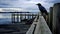 Dark Navy And Black: A Captivating Photo Of A Crow On An Old Pier