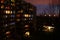 Dark night courtyard with luminous windows of an apartment building, urban concept