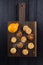 Dark oak cutting board with homemade cookies and lemon above vie