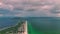 Dark ominous thunderstorm clouds forming on overcast sky during heavy rainfall season over ocean surface near suburbs