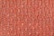 Dark orange knitted woolen background with a pattern of soft, fleecy cloth. Texture of textile closeup.