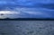 Dark overcast sky over the lake on a summer evening, gloomy clouds