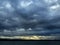 Dark overcast sky over the lake on a summer evening, gloomy clouds