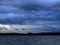 Dark overcast sky over the lake on a summer evening, gloomy clouds