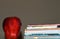 A dark photo of an apple beside a stack of children`s book for education