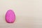 Dark pink decorative egg on a gray background.