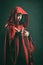 Dark portrait of a beautiful woman with red cloak