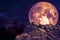 dark purple moon back over stone monster on rock of cliff